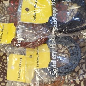 Four round braided leather bolo chords, black, 2 browns, and light blue/grey.